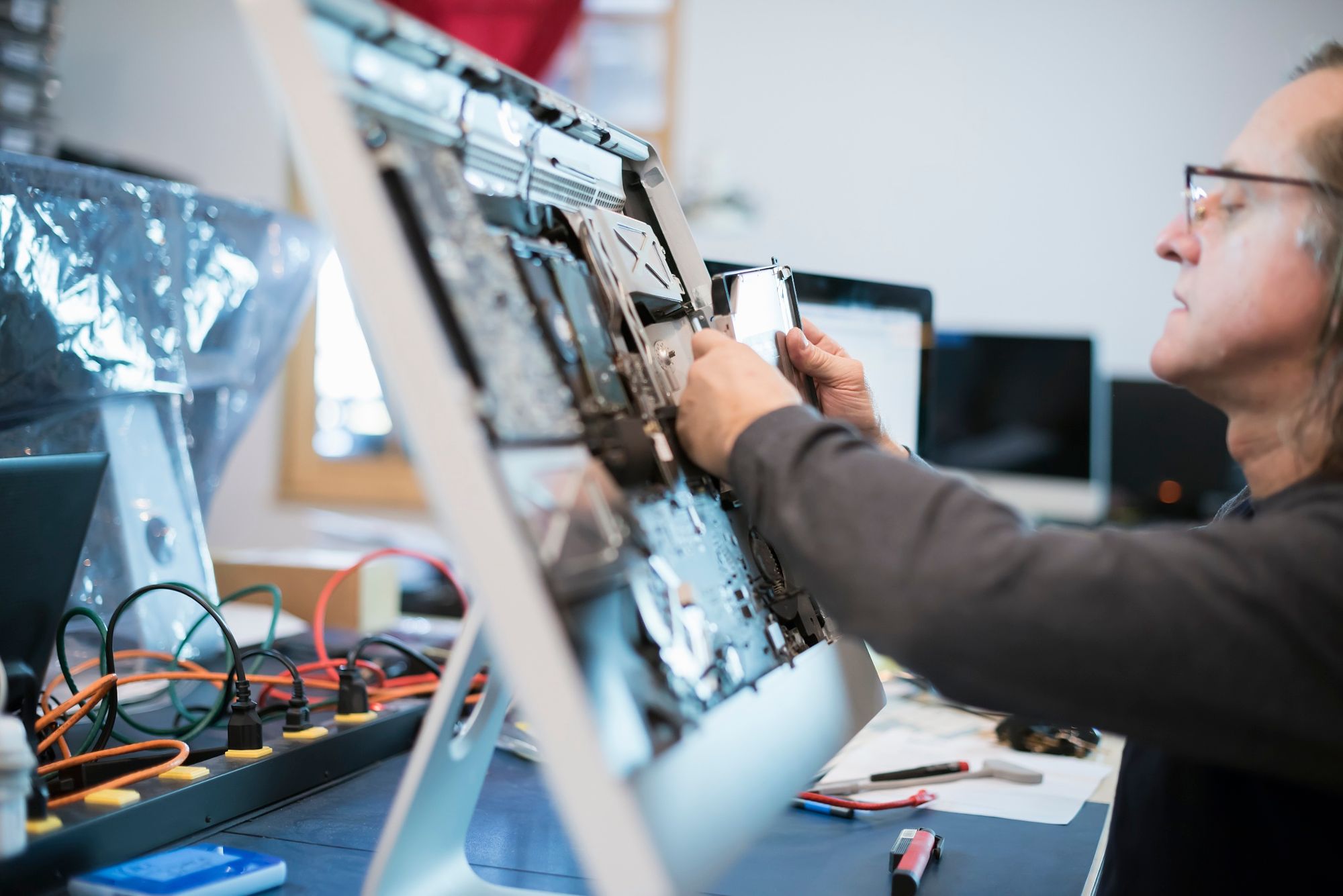 Computer Repair Shop. A man with a computer monitor, taking it apart to ...